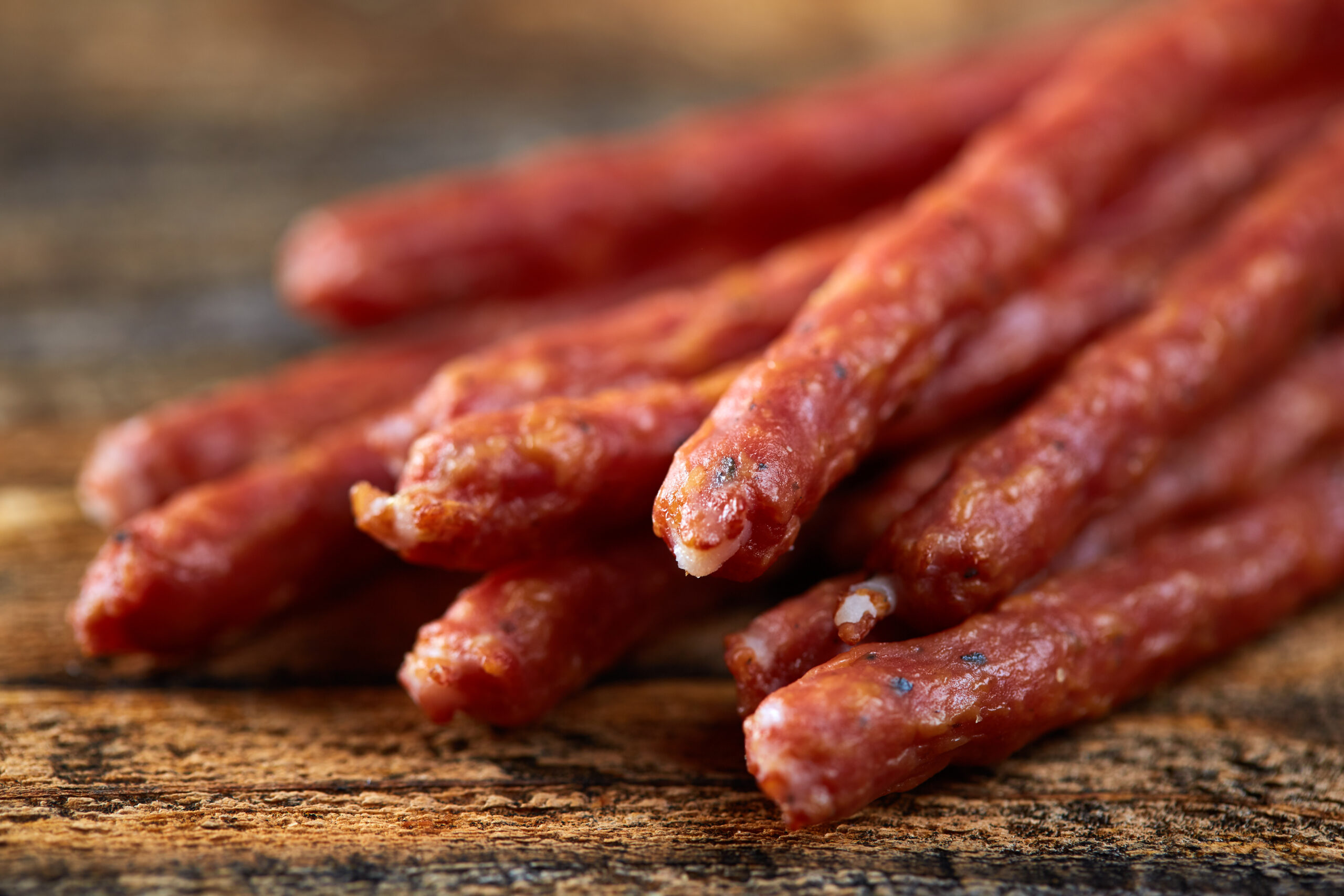 Sticks sausages on wooden board